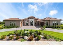 Stunning front exterior of this home with manicured landscaping and paver driveway at 209 Pine Lilly Ct, Lake Alfred, FL 33850
