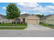 Charming single-story home featuring a manicured lawn, mature tree, and a two-car garage at 536 Squires Grove Dr, Winter Haven, FL 33880