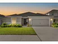 Charming single-story home featuring a well-manicured lawn, a two-car garage, and a welcoming front entrance at 716 Vittorio Dr, Winter Haven, FL 33884