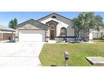 Charming single-story home featuring stone accents, arched windows and a well-manicured lawn at 7929 Ashley Pointe Dr, Lakeland, FL 33810