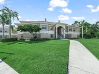 Inviting condo building with landscaped lawn, walkway, and stairs to units at 1507 Eagle Pond Dr # 1507, Winter Haven, FL 33884
