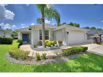 Charming single-story home with landscaped front yard, palm tree, and blue front door at 2350 Paulette Dr, Haines City, FL 33844