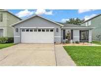 Charming single-story home with a two-car garage, green lawn, and landscaped front at 2602 Whitewood Rd, Mulberry, FL 33860