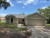 Charming single-story home featuring an attached two-car garage and a concrete driveway at 300 E Washington St, Minneola, FL 34715