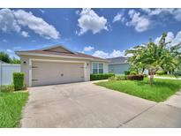 Charming single-Gathering home showcasing a lush lawn, lovely landscaping, and a convenient two-car garage at 373 St Georges Cir, Eagle Lake, FL 33839