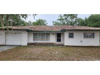 Charming single-story home featuring a red tile roof, front lawn, and attached one car garage at 4160 Poinciana Dr, Indian Lake Estates, FL 33855