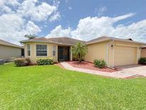 Charming single-story home with well-maintained landscaping and a brick walkway at 4469 Turnberry Ln, Lake Wales, FL 33859