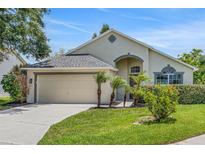 Charming one-story home featuring a well-manicured lawn, mature trees, and an attached two-car garage at 529 Terranova Cir, Winter Haven, FL 33884