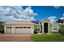 Charming single-story home boasts a three-car garage, lush lawn, and well-maintained landscaping at 5340 Nicklaus Dr, Winter Haven, FL 33884