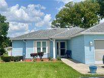 Charming single-story home features a well-manicured lawn and inviting front entrance with a chair at 6192 Magpie Dr, Lakeland, FL 33809