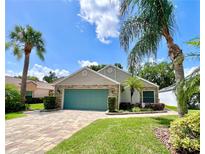 Charming single-story home with a well-maintained lawn, lush landscaping, and a brick-paved driveway at 741 Canberra Rd, Winter Haven, FL 33884