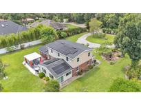 An aerial view shows this lovely two story home with a brick and siding exterior and solar panels at 1125 Rolling Woods Ln, Lakeland, FL 33813