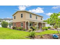 Charming two-story home with a brick facade and inviting, well-manicured front yard at 1125 Rolling Woods Ln, Lakeland, FL 33813