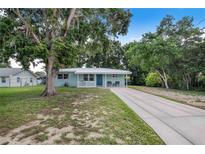 Charming single-story home with a well-maintained lawn, covered front porch, and a long, concrete driveway at 124 Tyler St, Lake Wales, FL 33859