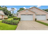 Charming home featuring a white garage door, complemented by lush landscaping and a well-maintained driveway at 13 Enclave Dr, Winter Haven, FL 33884