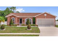 Charming single-story home featuring a well-manicured lawn and a two-car garage at 1366 Merrimack Pl, Davenport, FL 33837