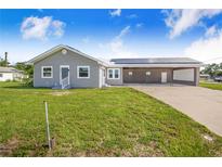 Charming single-story home with gray siding, metal roof, solar panels and spacious carport at 2218 Melbourne Ave, Haines City, FL 33844