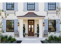 Charming home entrance with copper awning, a wood door, blue shutters, and a landscaped front yard at 2300 Scenic N Hwy # 51, Lake Wales, FL 33898