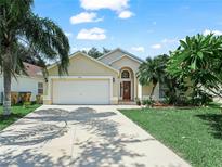 Charming single-story home with a well-maintained lawn, palm trees, and a two-car garage at 2538 Crown Ridge Cir, Kissimmee, FL 34744