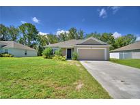 Charming single-story home featuring a well-maintained lawn, inviting entrance, and attached two-car garage at 286 Cove At Eagle Lake Cir, Eagle Lake, FL 33839