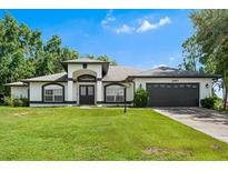 Charming single-story home with manicured lawn, dark trim and a two car garage at 2861 Pond View Dr, Haines City, FL 33844
