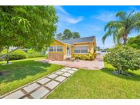 Charming yellow home with a well-manicured lawn, stone accents, and a pathway to the front door at 345 Avenue J Se, Winter Haven, FL 33880