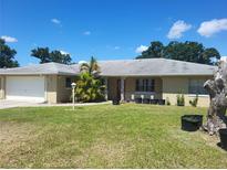 Charming single-story home with well-manicured lawn, front porch with black flower pots, and a brick exterior at 514 7Th S St, Dundee, FL 33838