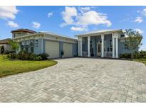 Stunning single-story home features a brick driveway, lush landscaping, and a welcoming covered porch at 545 Pond Cypress Ct, Auburndale, FL 33823