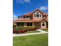 Charming townhome features a red tile roof, lush landscaping, and a welcoming entrance at 7906 Waterview Way # 7906, Winter Haven, FL 33884