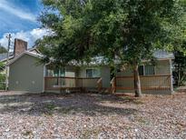 Charming single-story home with a wooden deck and mature trees providing shade at 914 Mangham Rd, Babson Park, FL 33827