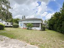 Charming home featuring a screened porch, solar panels, and a spacious lawn with mature trees at 1127 S Lakeshore Blvd, Lake Wales, FL 33853