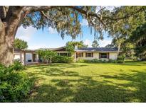 Charming one story home with mature trees, brick chimney, red shutters and lush front lawn at 1317 Avenue A Se, Winter Haven, FL 33880