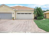 Well-maintained home with a brick paver driveway that leads to a two car garage with beautiful landscaping at 1349 Innsbruck Ct, Winter Haven, FL 33884