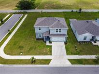 Aerial view of a two-story home featuring a well-manicured lawn and gray color scheme at 137 Piave St, Haines City, FL 33844