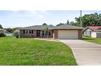 Charming single-story brick home with a well-manicured lawn and attached garage at 165 Lagoon Rd, Winter Haven, FL 33884