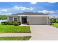 Charming one-story home with a well-manicured lawn and a two-car garage at 1976 Harvest Landing Cir, Lakeland, FL 33810