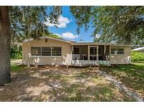 Charming single-story home with mature trees, a screened-in porch, and a tidy, shaded front yard at 208 Lake Dale Dr, Auburndale, FL 33823