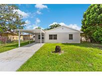 Charming single-story home featuring a carport and well-maintained lawn at 216 Pike St, Auburndale, FL 33823