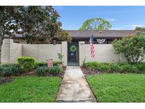 Charming home featuring a landscaped front yard with walkway, flowerbeds, and an American flag at 2282 Firestone Pl, Winter Haven, FL 33884