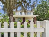 Charming two-story home featuring a white picket fence and mature trees in a serene setting at 2418 W 1St St, Sanford, FL 32771