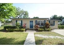 Charming home featuring mature landscaping, a well-manicured lawn, and a welcoming blue front door at 520 Oakland Rd, Auburndale, FL 33823