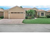 Charming single-story home with a two-car garage, well-manicured lawn, and mature palm trees at 5200 Pebble Beach Blvd, Winter Haven, FL 33884