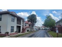 A street view showing apartments and townhomes with red tile roofs and red railings in a residential neighborhood at 6294 River Run Pl # 193, Orlando, FL 32807