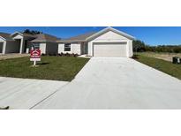 Charming single-story home featuring a two-car garage, well-maintained lawn, and inviting curb appeal at 221 Harper Estates Cir, Lake Wales, FL 33859