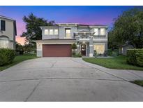 Two-story house with a gray exterior, red door, and landscaped yard at 1541 Truscott Ct, Mount Dora, FL 32757