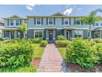 Two-story townhome with gray exterior, landscaped yard, and brick walkway at 16039 Juniper Inlet Aly, Winter Garden, FL 34787