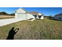 Newly constructed home with a two-car garage and well-manicured lawn at 2177 Emma Ln, Lake Wales, FL 33859