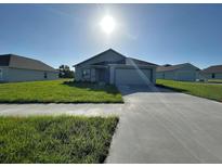 Charming single-story home featuring a well-maintained lawn, driveway, and attached garage at 2181 Emma Ln, Lake Wales, FL 33859