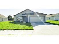 Charming single-story home with a well-manicured lawn and attached two-car garage at 2181 Emma Ln, Lake Wales, FL 33859