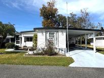 Charming single-story home featuring a covered carport and well-maintained landscaping in a sunny locale at 102 Willow Ln, Leesburg, FL 34748